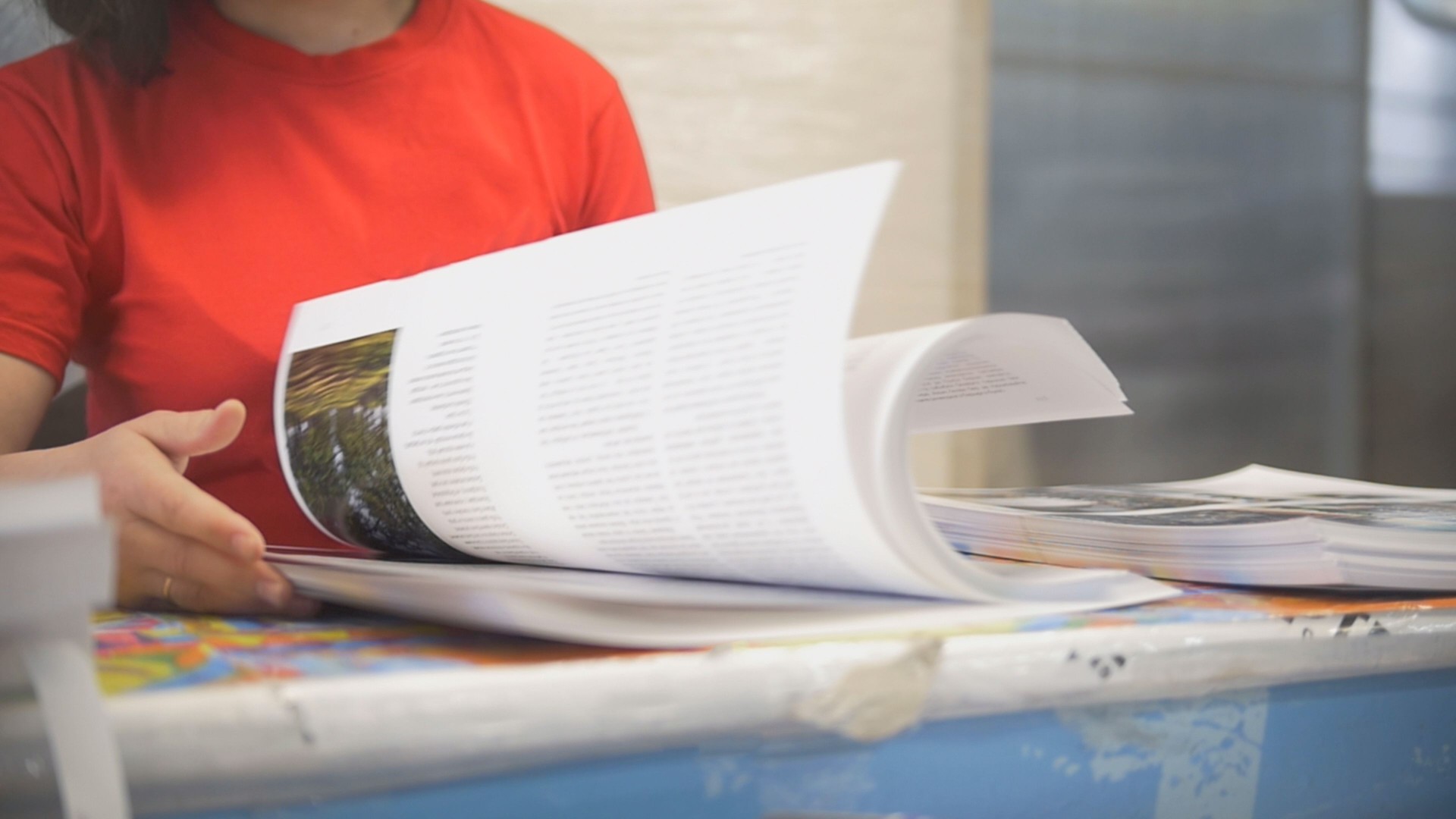 Hands of female worker in typography turning printed pages