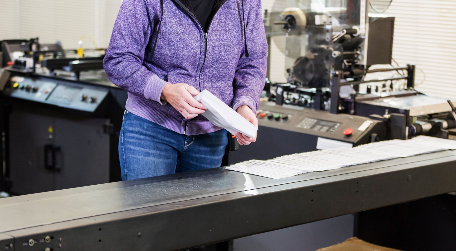Woman in printing factory with mass mailing machine